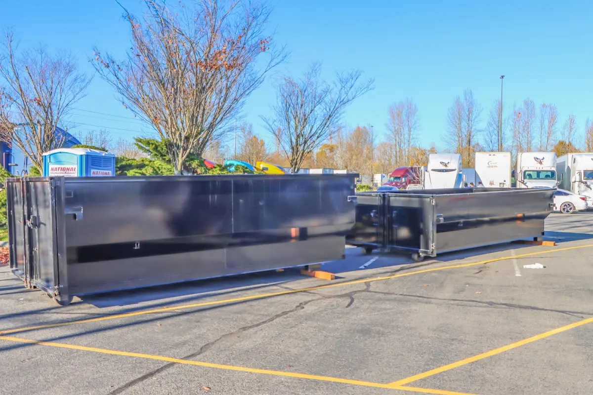 Professional dumpster rental service with roll-off container on residential driveway in Vernon